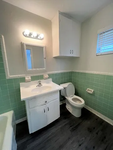 a bathroom with a toilet sink and mirror
