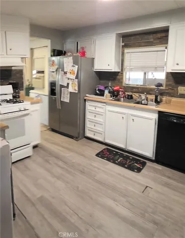 a kitchen with stainless steel appliances a refrigerator sink and cabinets