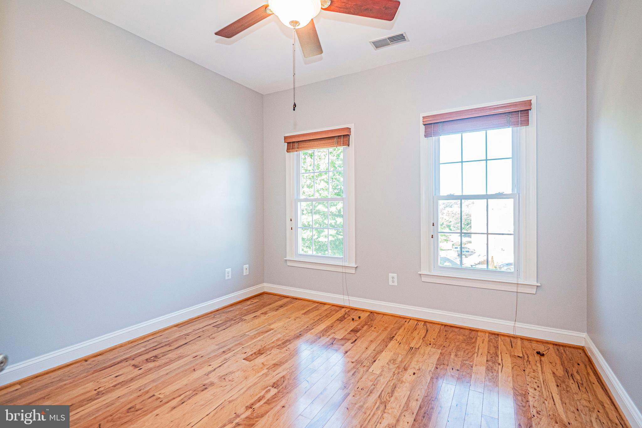 5448 Edsall Ridge Place Alexandria, VA 22312 - Photo 29 of 52 an empty room with wooden floor chandelier fan and windows