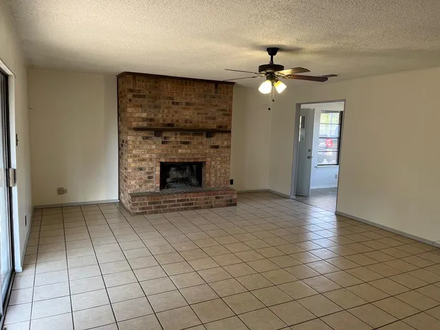 an empty room with fireplace and fan