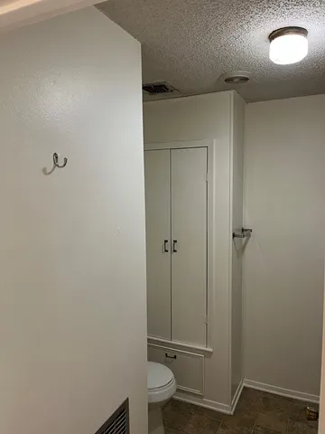 a bathroom with a granite countertop toilet and a sink