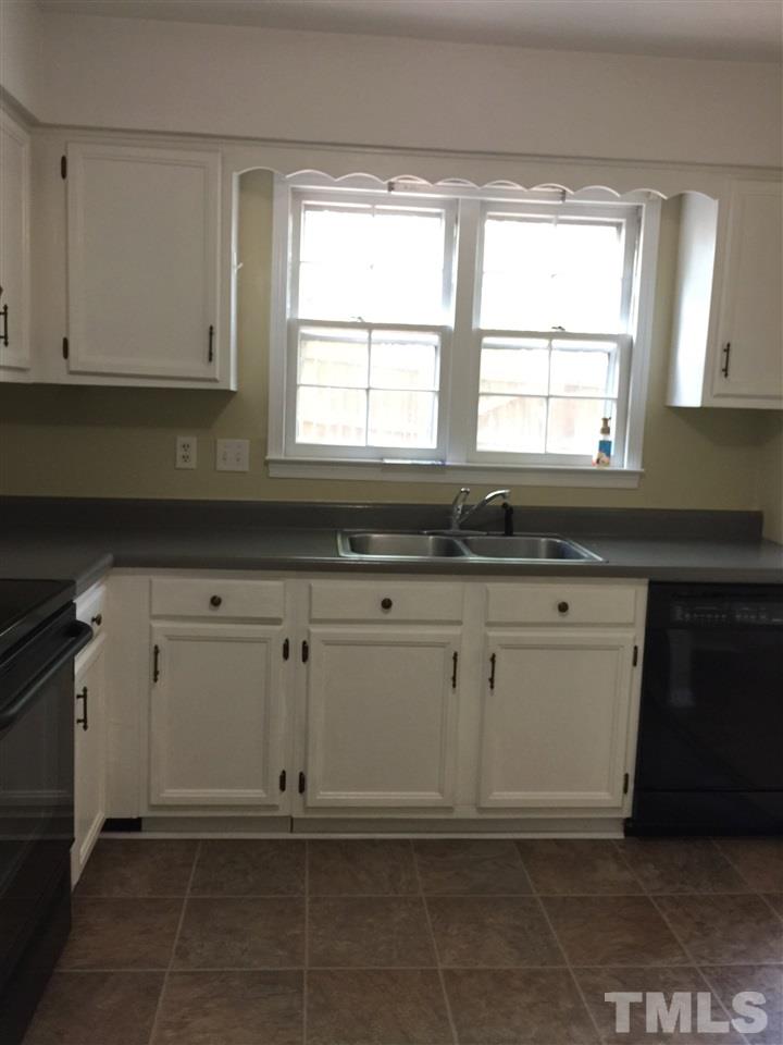 1034 Randolph Court Cary, NC 27511 - Photo 6 of 14 a kitchen with white cabinets and a window