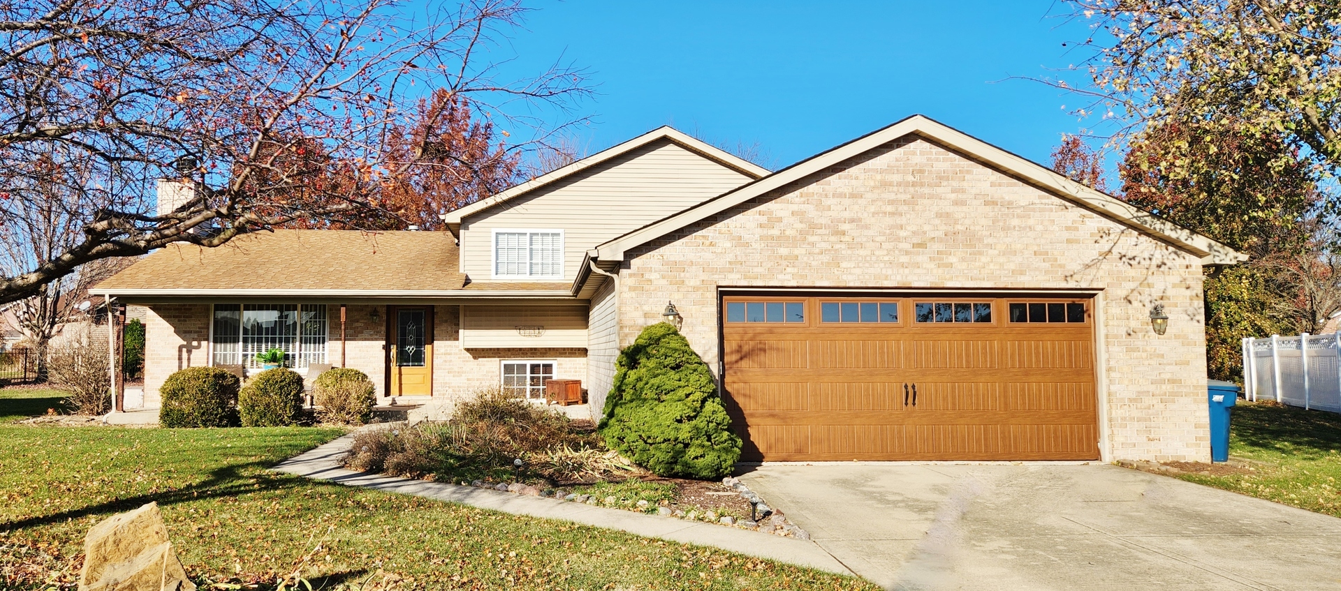 1445 Scott Circle Morris, IL 60450 - Photo 2 of 31 a view of a grey house with small yard plants and a large tree