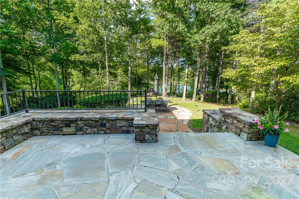 146 Allison Creek Trail Brevard, NC 28712 - Photo 42 of 48 a view of a backyard with lawn chairs plants and large tree