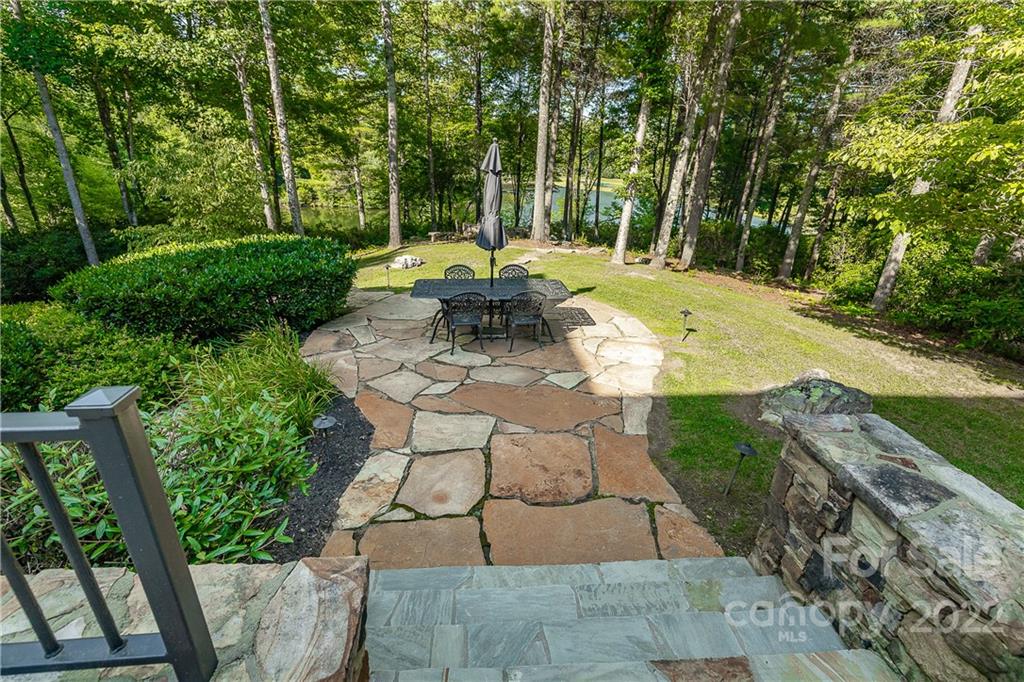 146 Allison Creek Trail Brevard, NC 28712 - Photo 43 of 48 a view of a patio with table and chairs potted plants and large tree