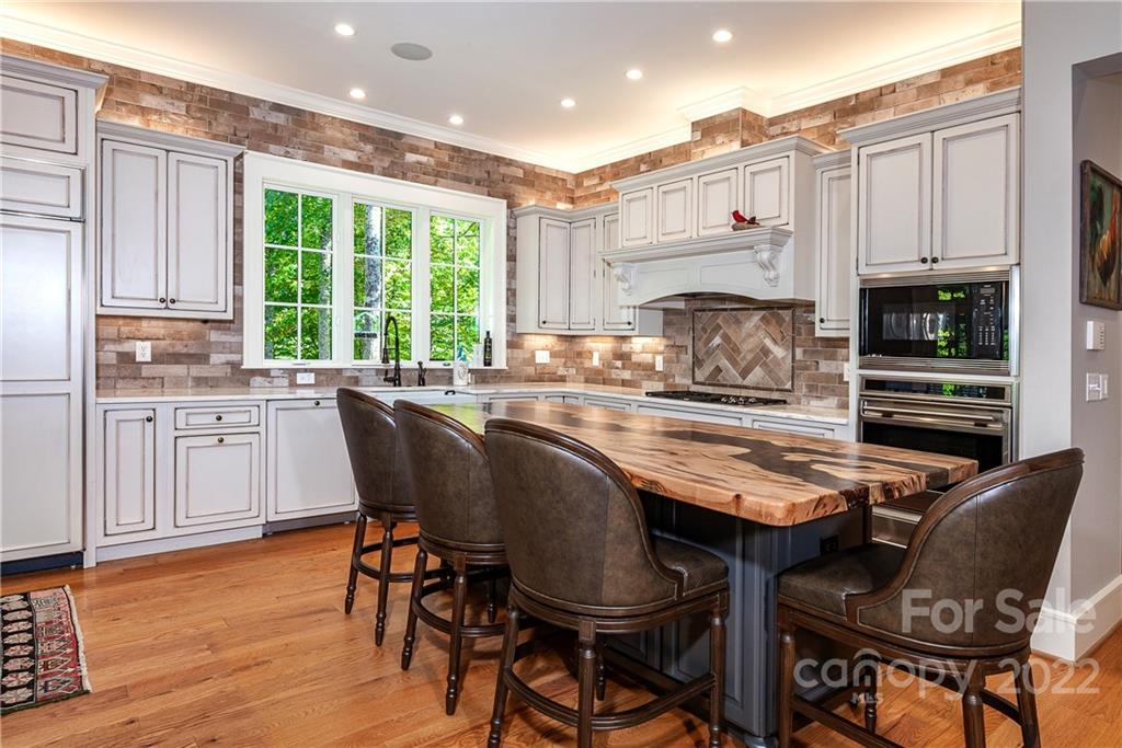 146 Allison Creek Trail Brevard, NC 28712 - Photo 9 of 48 a kitchen with kitchen island granite countertop a table chairs microwave and cabinets