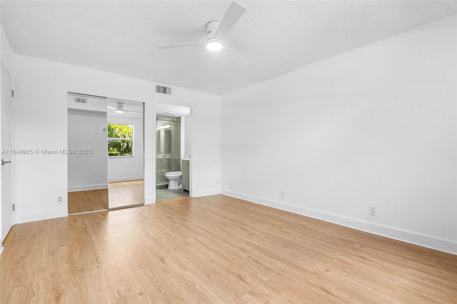 8721 Wiles Road, Unit 105 Coral Springs, FL 33067 - Photo 12 of 49 an empty room with wooden floor and windows