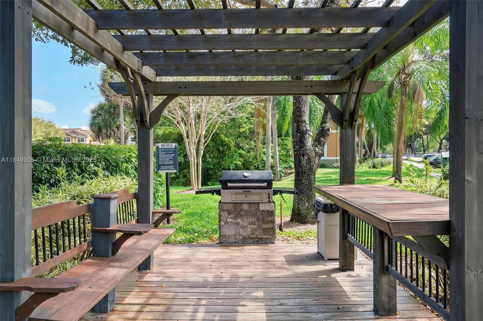 8721 Wiles Road, Unit 105 Coral Springs, FL 33067 - Photo 46 of 49 a view of a patio with a table chairs and a backyard
