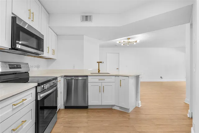 a kitchen with stainless steel appliances granite countertop a sink and stove top oven
