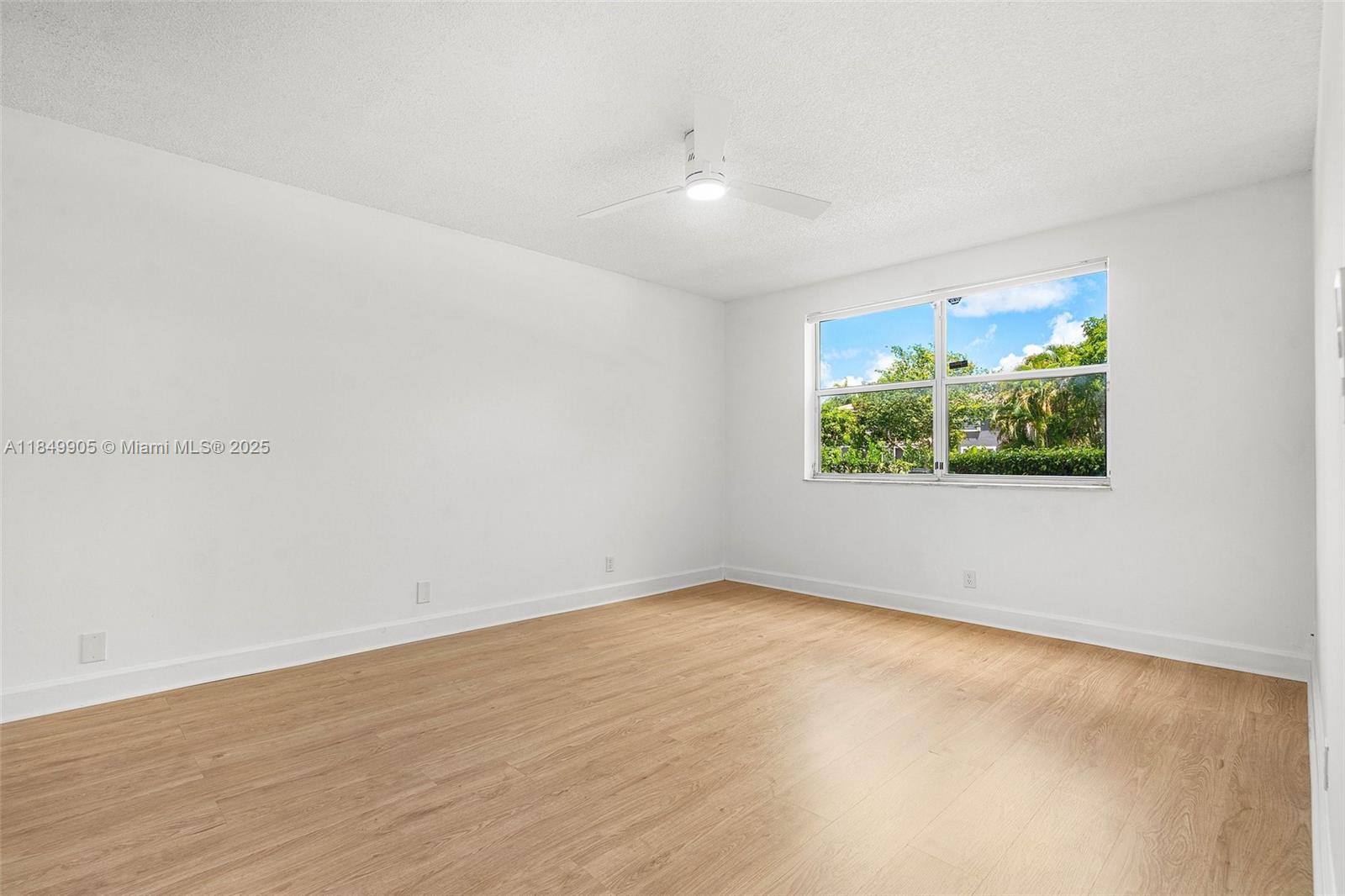 8721 Wiles Road, Unit 105 Coral Springs, FL 33067 - Photo 9 of 49 an empty room with wooden floor and windows