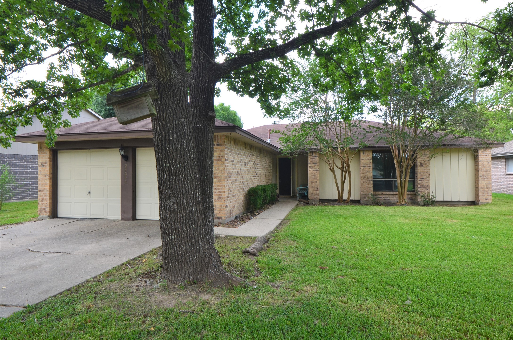 a front view of a house with a garden and yard