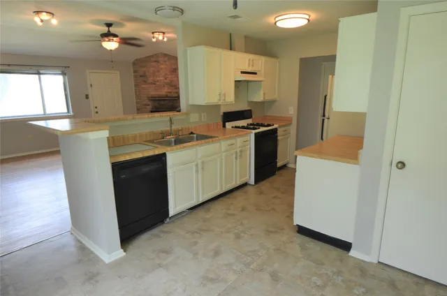 a kitchen with a sink cabinets and wooden floor