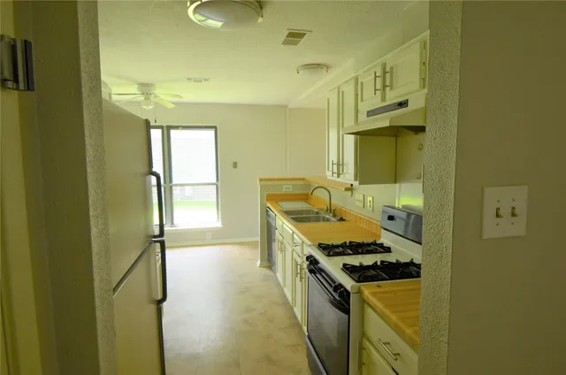 a kitchen with a stove and a wooden cabinets