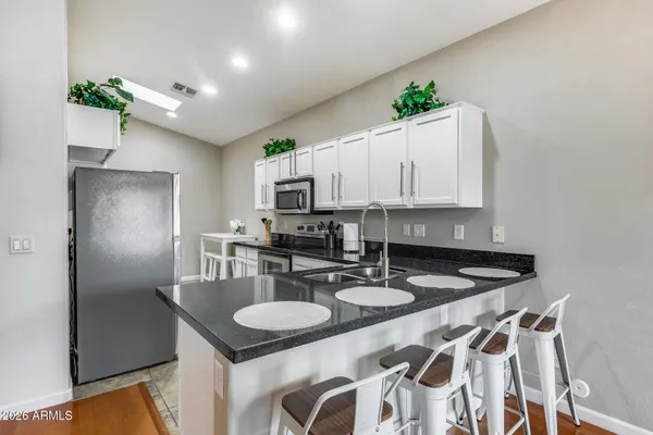 a kitchen with a dining table chairs and white cabinets