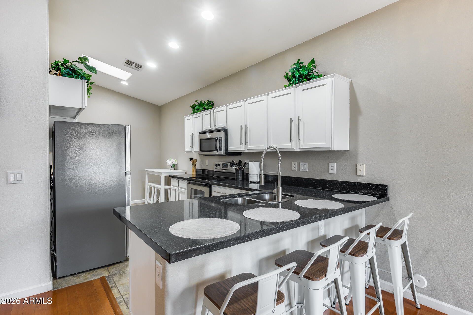 3252 East Fremont Road Phoenix, AZ 85042 - Photo 23 of 45 a kitchen with kitchen island granite countertop a sink and cabinets
