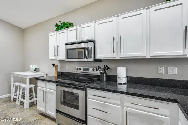 a kitchen with kitchen island granite countertop a sink and cabinets