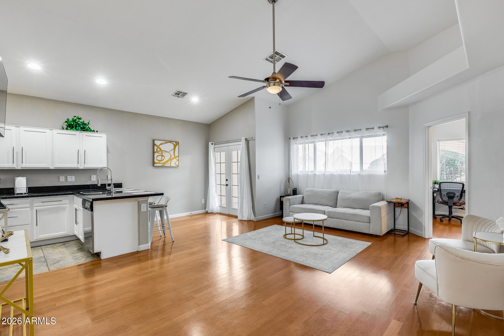 3252 East Fremont Road Phoenix, AZ 85042 - Photo 2 of 45 a living room with kitchen island granite countertop wooden floor and a ceiling fan