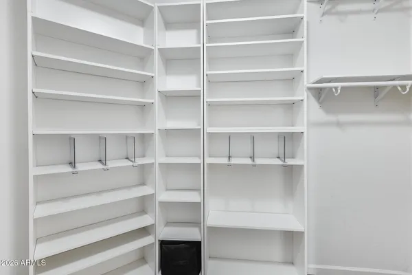 a view of walk in closet with empty racks