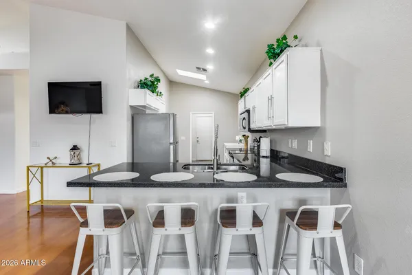 a kitchen with granite countertop white cabinets stainless steel appliances and a sink