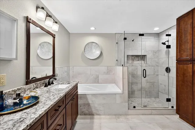 a bathroom with a granite countertop sink mirror and shower