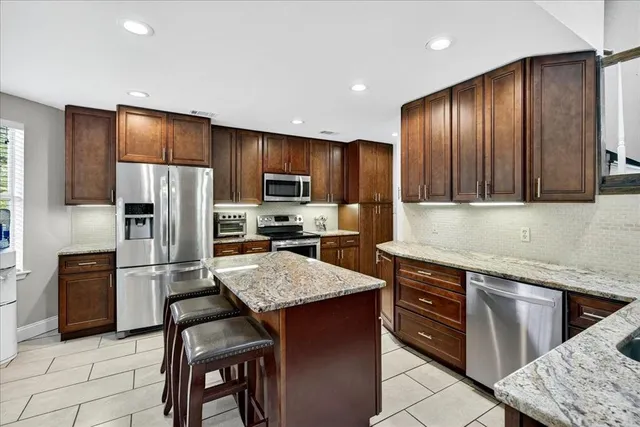 a kitchen with granite countertop stainless steel appliances and wooden cabinets