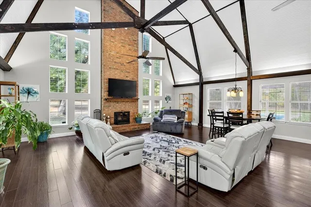 a living room with fireplace furniture and a large window