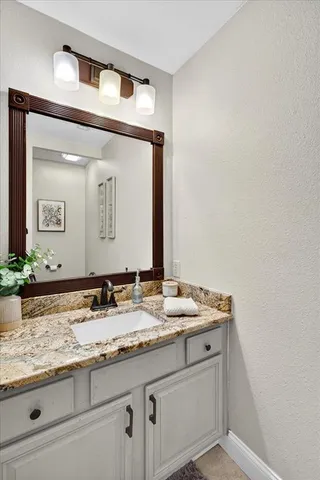 a bathroom with a granite countertop sink and a mirror