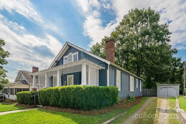 a front view of a house with a yard and potted plants