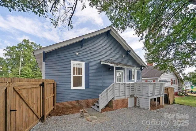 a view of house with a yard and large tree