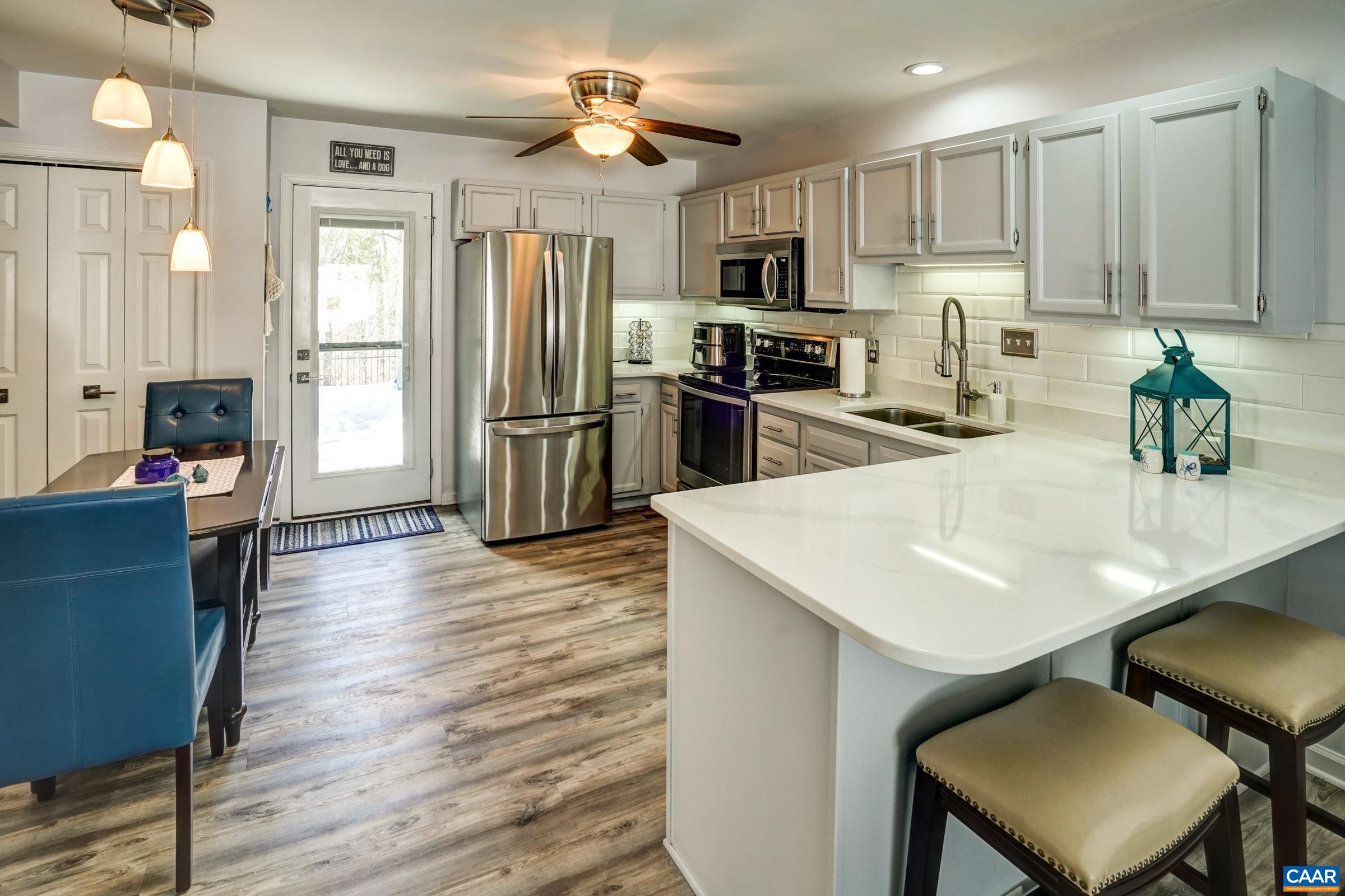 1008 Highlands Drive Charlottesville, VA 22901 - Photo 8 of 41 a kitchen with stainless steel appliances kitchen island granite countertop a refrigerator a stove a sink dishwasher and white cabinets with wooden floor