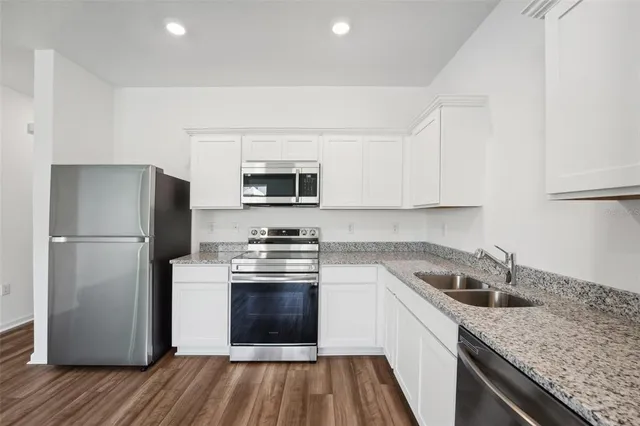 a kitchen with stainless steel appliances granite countertop a stove and a microwave