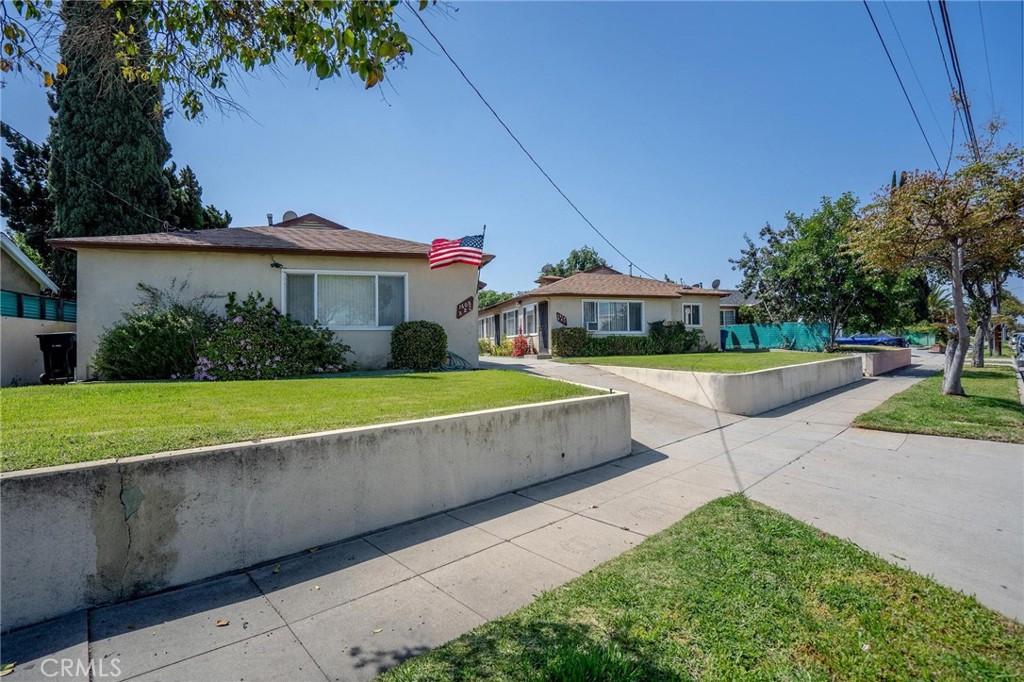 a view of house with garden and tall trees