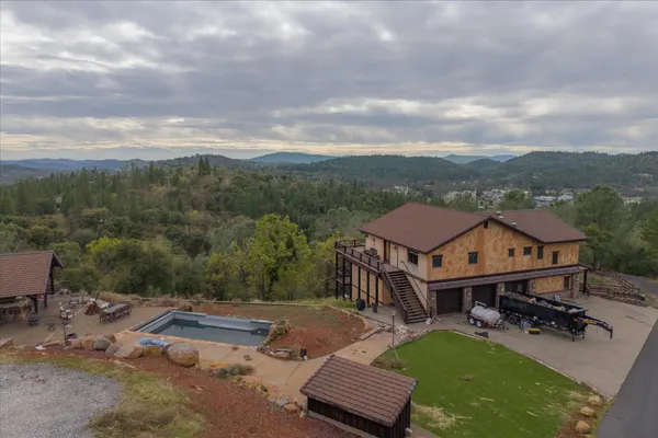 an aerial view of a house with backyard garden and patio
