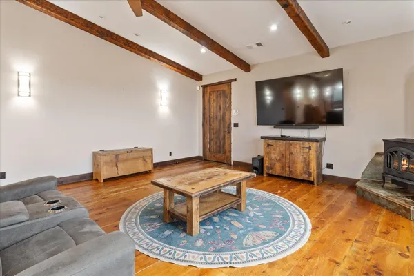 a kitchen with a refrigerator a stove and a sink with wooden floor