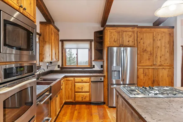 a kitchen with stainless steel appliances granite countertop a sink a stove and a refrigerator