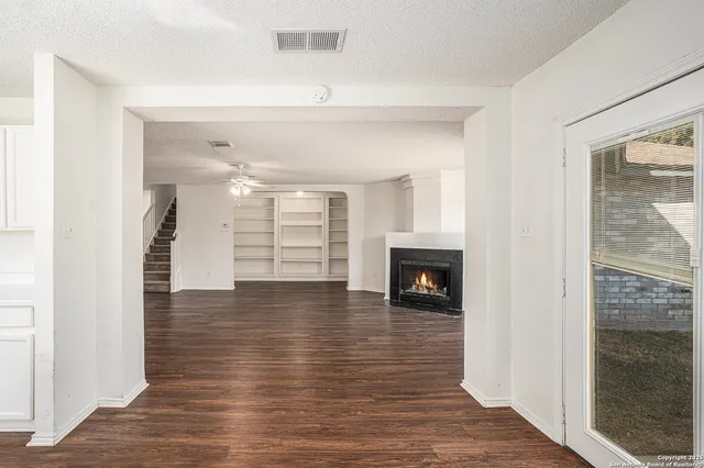 a view of a livingroom with wooden floor and a fireplace