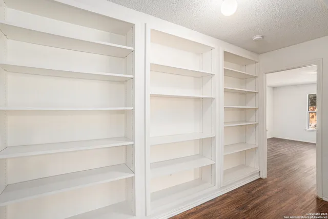 a view of walk in closet with empty racks
