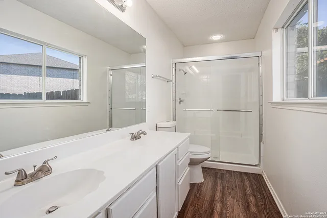 a bathroom with a sink a toilet and shower