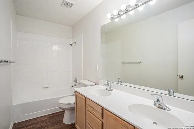a bathroom with a double vanity sink toilet and a mirror