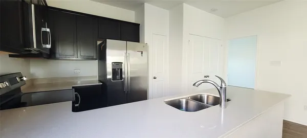 a kitchen with a refrigerator sink and cabinets