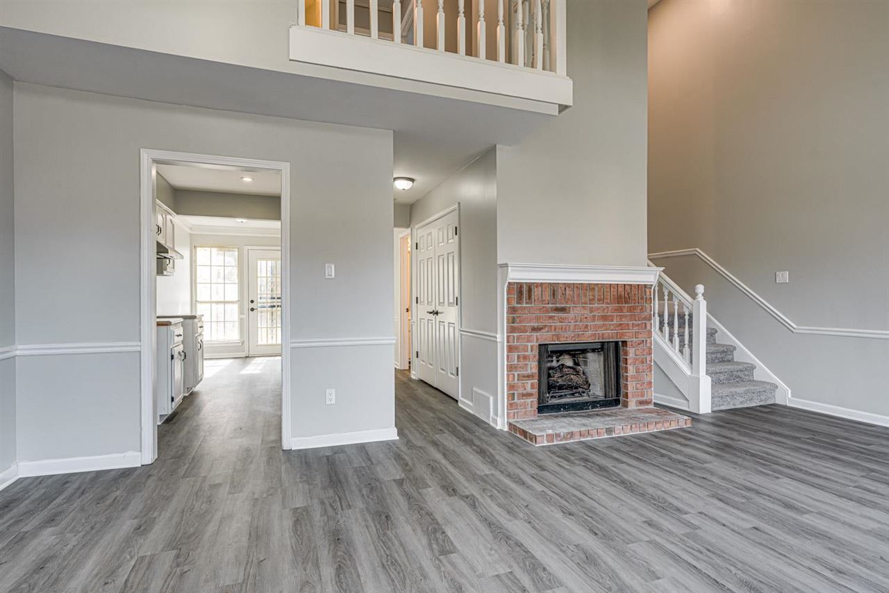 6853 Snyder Road Memphis, TN 38141 - Photo 4 of 23 a view of a livingroom with wooden floor a fireplace and windows