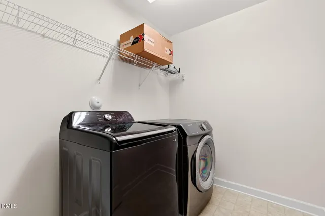 a view of a white house with a large windows and wooden fence