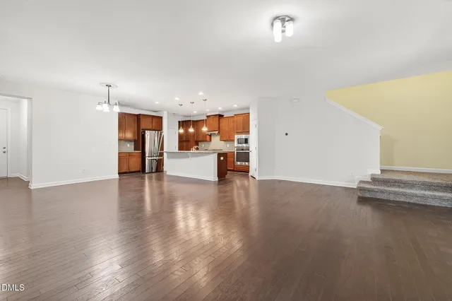 a kitchen with stainless steel appliances granite countertop a sink a counter space and wooden floors