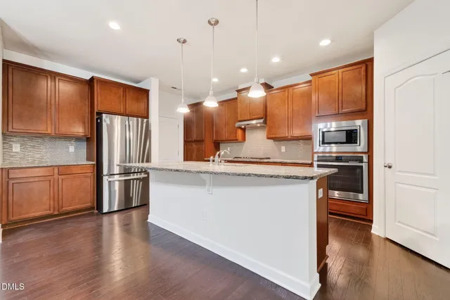 a kitchen with stainless steel appliances granite countertop a sink and cabinets