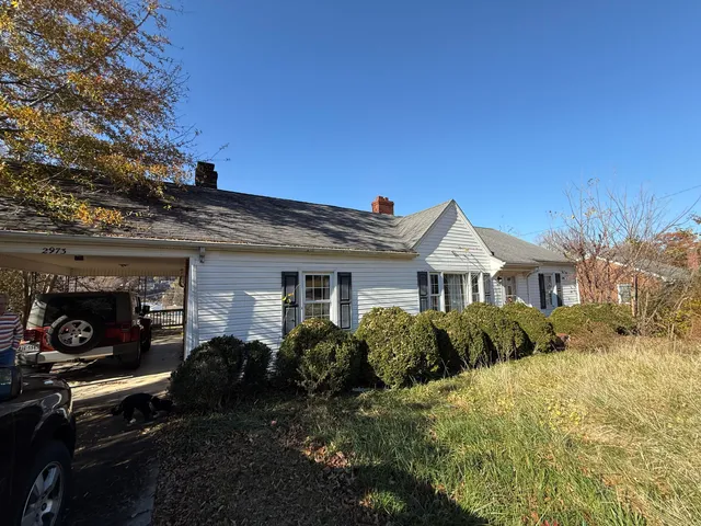 a front view of house with yard and trees around
