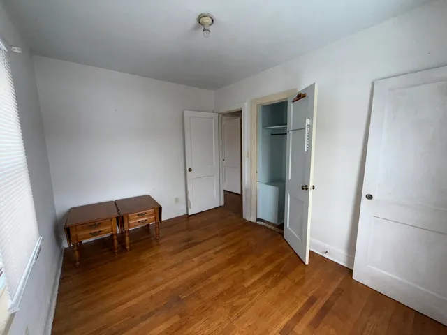 a view of room with wooden floor and furniture