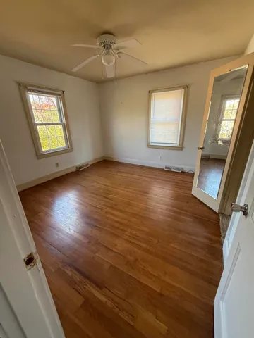 wooden floor in an empty room with a window