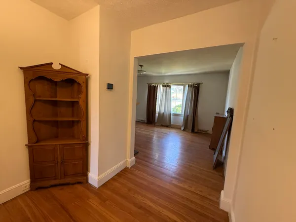 a view of a hallway with wooden floor and closet