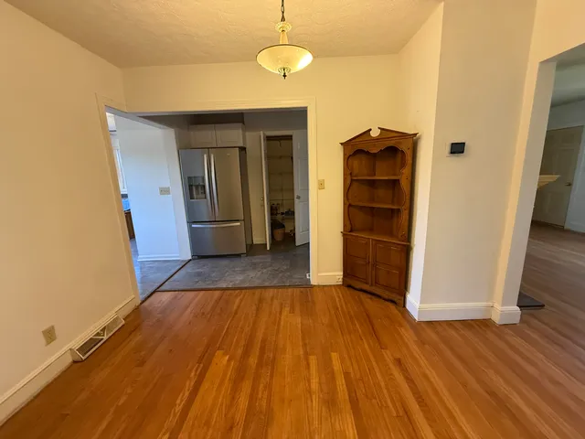 a view of a room with wooden floor and cabinets