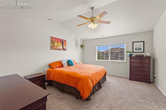 6310 Pilgrimage Road Colorado Springs, CO 80925 - Photo 22 of 31 Carpeted bedroom with ceiling fan and lofted ceiling